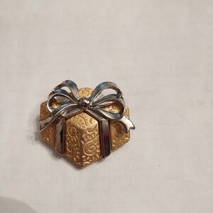Gold colored present brooch